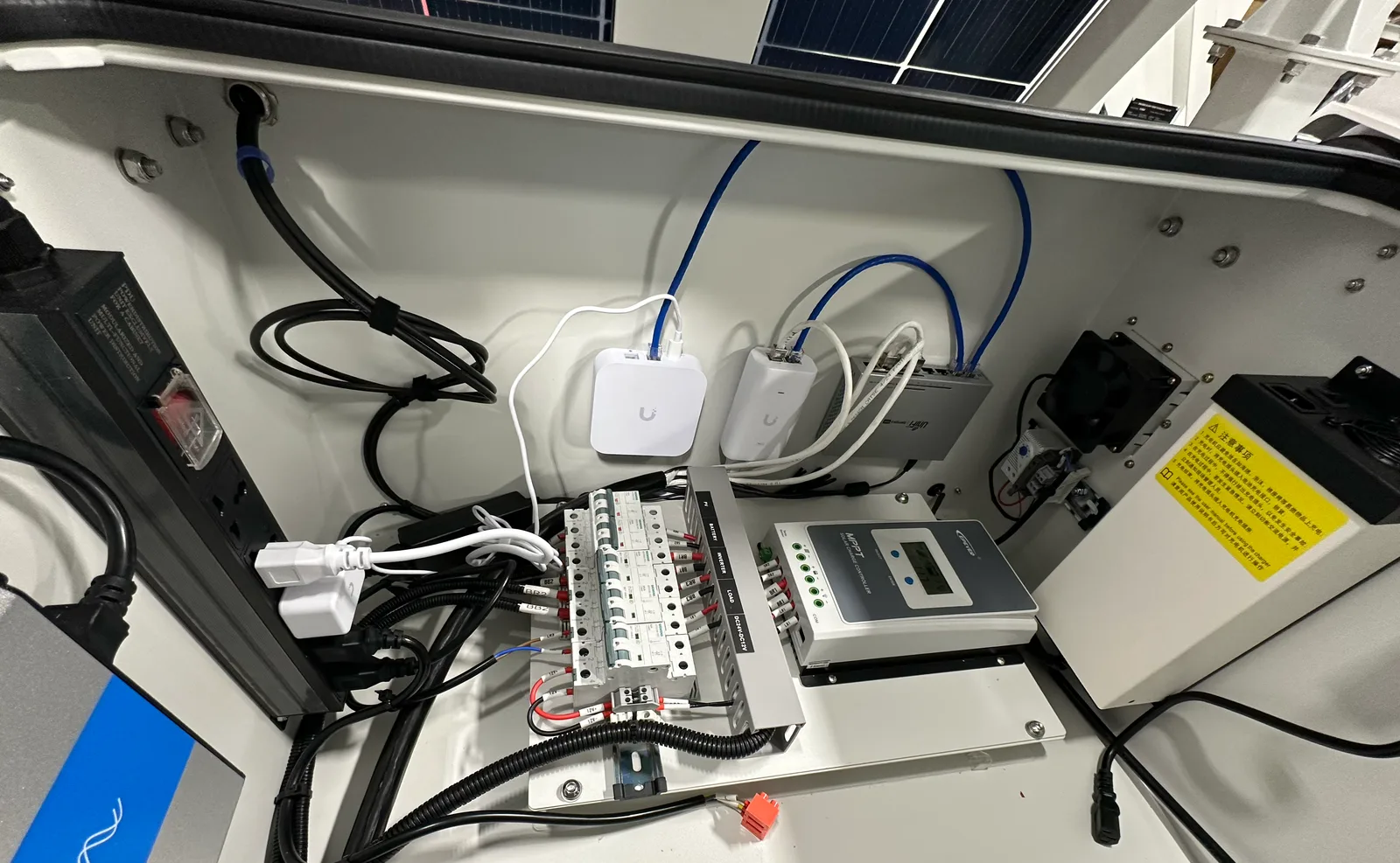 Inside the equipment cabinet: breaker rail, controller, and network gear